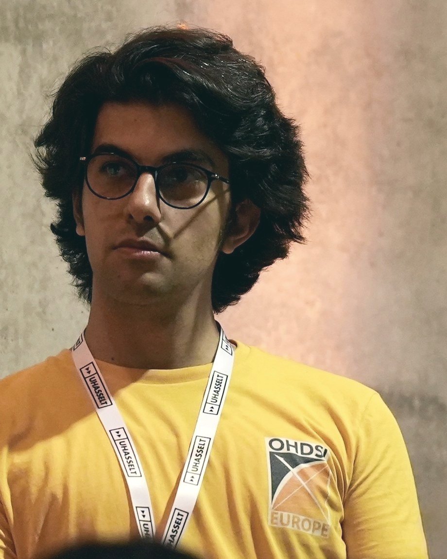 Ashkan Pirmani, in an OHDSI Europe shirt and a Hasselt
                 University lanyard, looking to the left of the camera.